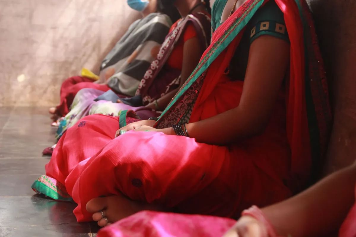 A photo of women sitting close to each other. 