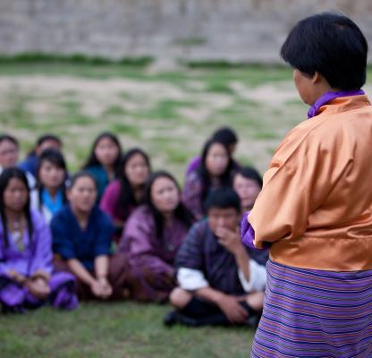 A group of people listening to a presenter. 