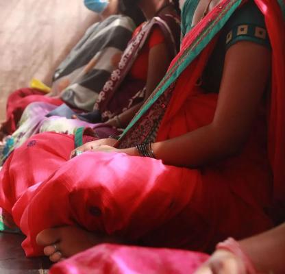 A photo of women sitting close to each other. 