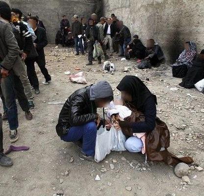 A group of people surround two women kneeling down on the ground. Photo Credits: Saied Goli/Mehr News Agency