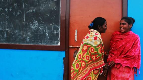 A photograph of two Indian women talking to each other. 