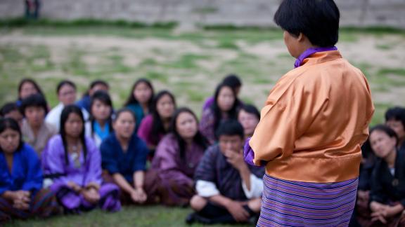 A counselor speaking as participants look on. 